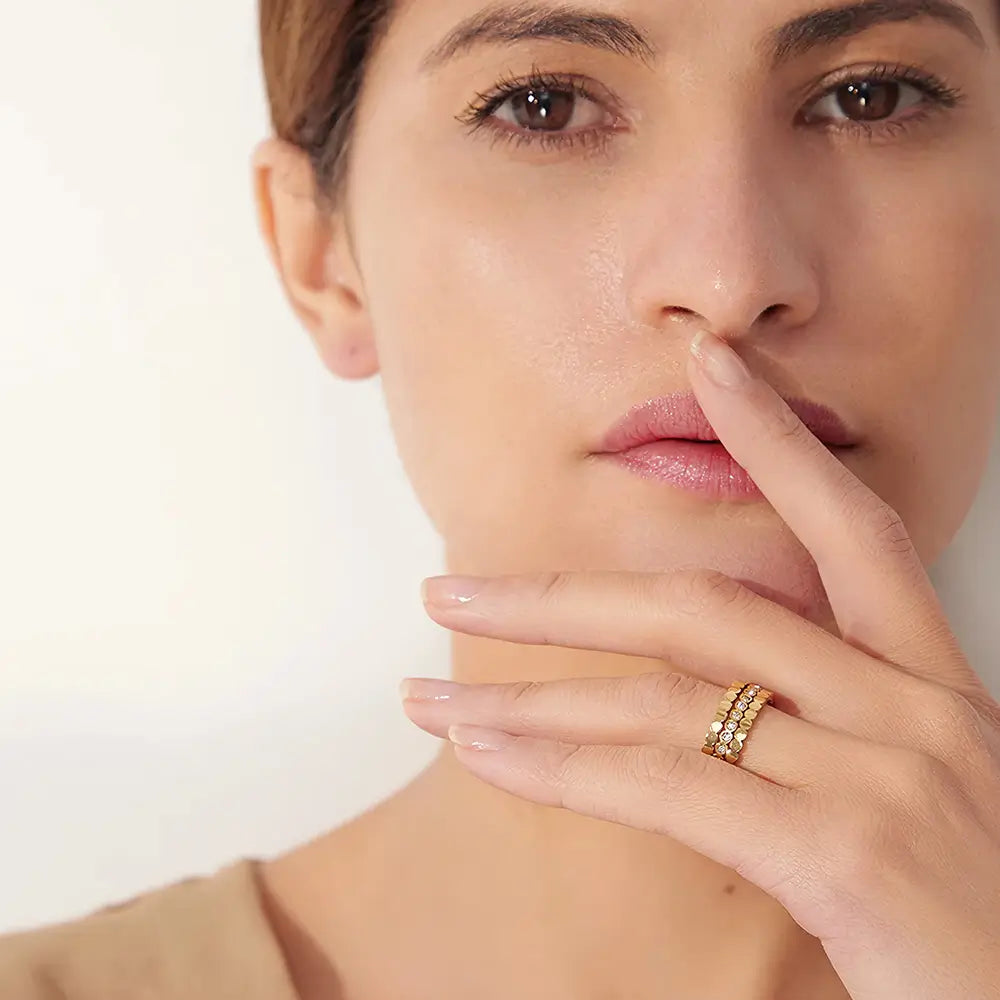 Mulher usando o Anel Feminino Dourado Triplo Ondulado com Zircônias Cúbicas Luminara - Banhado a Ouro 18k