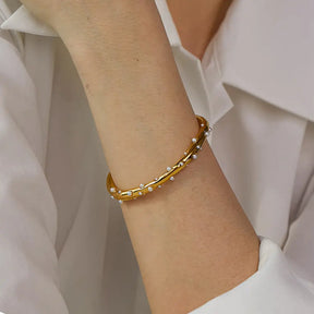 Bracelete Dourado Feminino cravejado com pérolas naturais e toque refinado