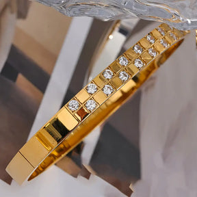 Bracelete Dourado Feminino cravejado com zircônias Seraphina, luminosidade destacada em cenário discreto