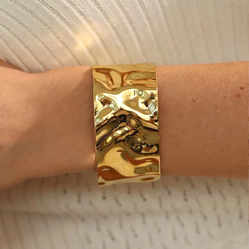 Bracelete Dourado Feminino largo grosso ondulado com formato moderno e brilho dourado, modelo usando