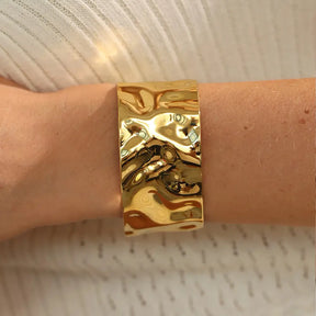 Bracelete Dourado Feminino largo grosso ondulado com formato moderno e brilho dourado, modelo usando