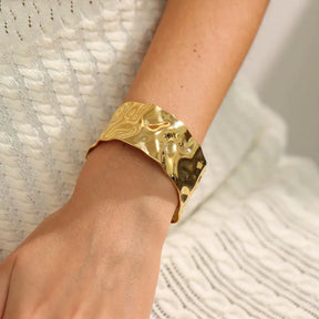 Bracelete Dourado Feminino largo grosso ondulado com textura fluida e toque sofisticado, modelo usando