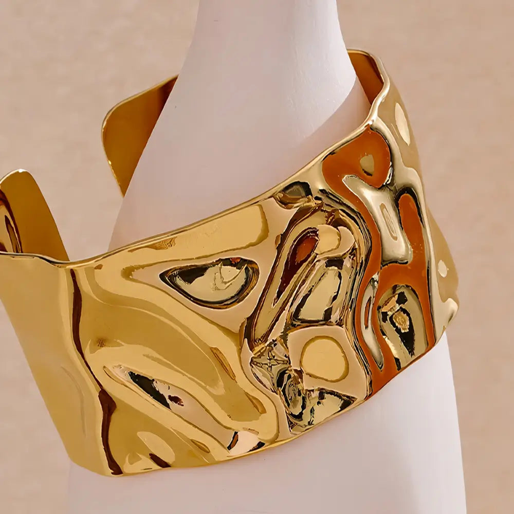 Bracelete Dourado Feminino largo grosso ondulado com design contemporâneo em fundo neutro