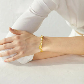 Bracelete Dourado Feminino rígido aberto irregular com estrutura marcante e toque artístico