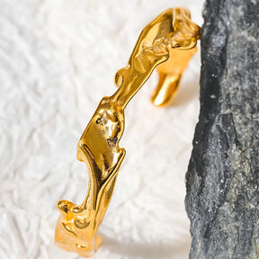 Bracelete Dourado Feminino rígido aberto Yara com formas assimétricas em ambiente clean