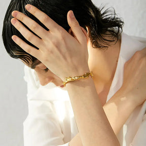 Bracelete Dourado Feminino rígido aberto Yara com curvas modernas e banho de ouro 18k