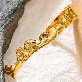 Bracelete Dourado Feminino rígido aberto irregular com destaque para o brilho em fundo claro
