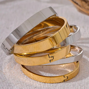 Bracelete Dourado Feminino rígido minimalista com design limpo e brilho sutil, fundo neutro