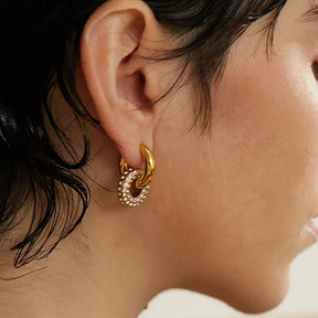 Mulher usando o Brinco Feminino Argola Dourada com Arco Cravejado de Zircônias Selina - Banhado a Ouro 18k, foto lateral do rosto com detalhes