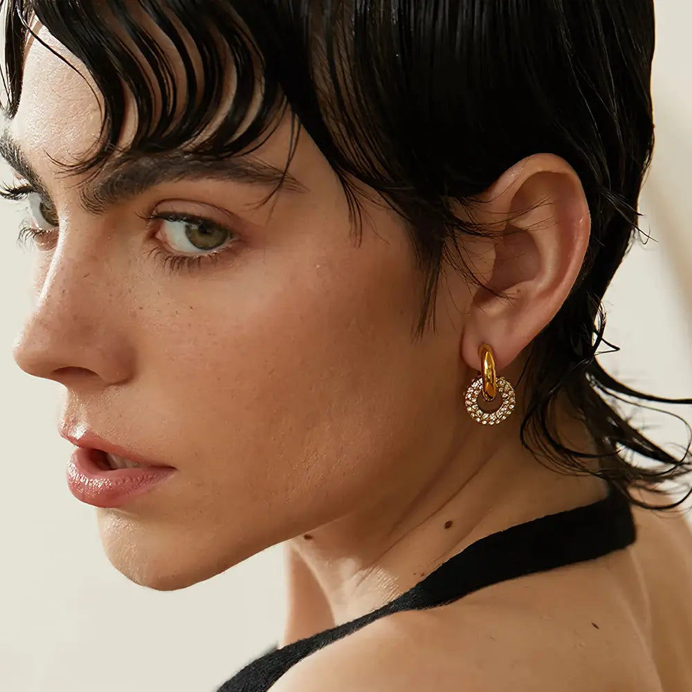 Mulher usando o Brinco Feminino Argola Dourada com Arco Cravejado de Zircônias Selina - Banhado a Ouro 18k