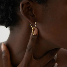 Mulher usando o Brinco Argola Feminino Dourado com Pingente de Coração Coraelle - Banhado a Ouro 18k