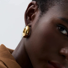 Foto frontal de perto da Mulher usando o Brinco Feminino Argola Dourada Grossa Chunky Véria - Banhado a Ouro 18k