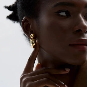 Foto de lado de uma Mulher usando o Brinco Feminino Argola Dourada Grossa Tipo C Thessa - Banhado a Ouro 18k