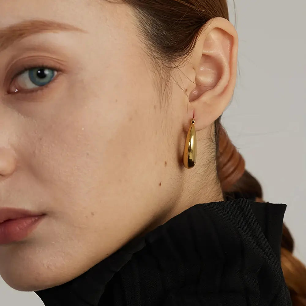 Mulher usando o Brinco Feminino Argola Dourada Larga Meia Lua Selene - Banhado a Ouro 18k