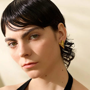 Mulher usando o Brinco Feminino Coração Valentina - Banhado a Ouro 18k