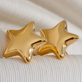 Brinco Feminino Dourado Stella com estrela polida em fundo neutro