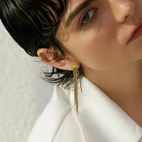 Brinco Feminino Dourado pendente com borla fina e textura delicada, modelo usando
