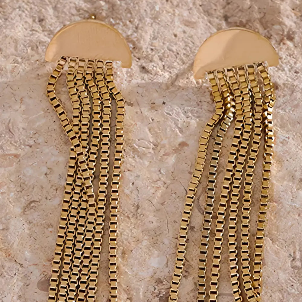 Brinco Feminino Dourado pendente com design de borla em fundo claro e elegante