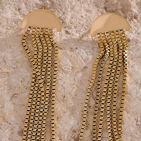Brinco Feminino Dourado pendente com design de borla em fundo claro e elegante
