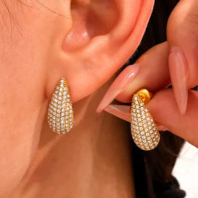 Mulher usando o Brinco Feminino Gota Dourado Cravejado com Zircônias Aurianne - Banhado a Ouro 18k