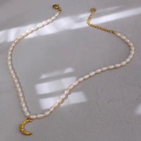 Colar Feminino de pérolas naturais com pingente meia lua dourada Celine, textura delicada e brilho suave em fundo claro