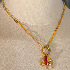 Colar Feminino Dourado com coração e berloques Melina em fundo neutro elegante