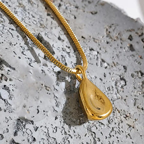 Colar Feminino Dourado corrente rabo de rato com pingente abstrato em ambiente clean e estilo contemporâneo