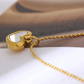 Colar Feminino Dourado de coração com concha natural em cenário claro e elegante