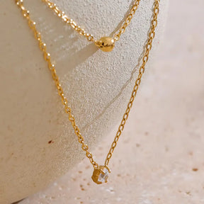 Colar Feminino Dourado duplo ponto de luz com zircônia Liora, delicadeza em cenário neutro e suave