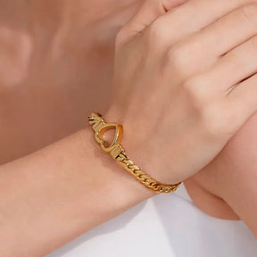 Foto de perto da Mulher usando a Pulseira Feminina Dourada Corrente Cubana Coração Amélie - Banhada a Ouro 18k