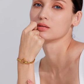 Mulher usando a Pulseira Feminina Dourada Corrente Cubana Coração Amélie - Banhada a Ouro 18k