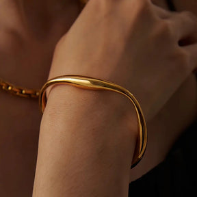 Foto de perto de uma Modelo usando a Pulseira Feminina Dourada Cuff Irregular Ajustável Aurora - Banhada a Ouro 18k