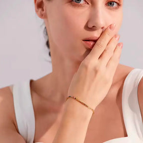 Mulher usando a Pulseira Feminina Dourada de Elos Retangulares e Zircônias Tingidas Liora - Banhada a Ouro 18k
