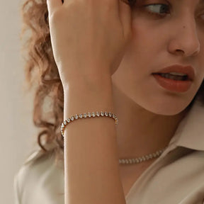 Modelo usando a Pulseira Feminina Dourada de Zircônias Cúbicas Évora - Banhada a Ouro 18k