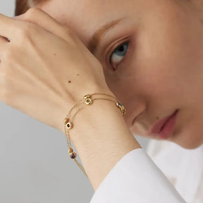 Mulher usando a Pulseira Feminina Dourada de Elos e Zircônias Tingidas Mirella - Banhada a Ouro 18k
