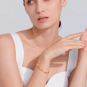 Mulher usando a Pulseira Feminina Dourada Ondas com Zircônias Cúbicas Elara - Banhada a Ouro 18k